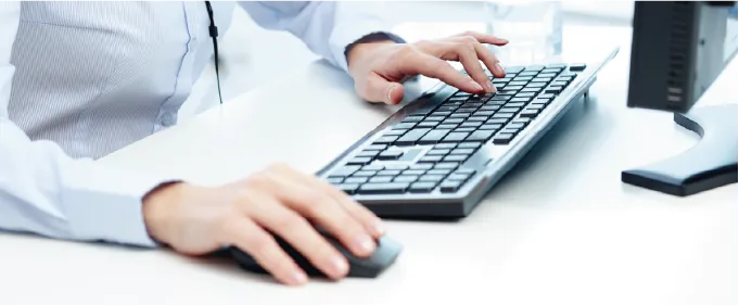 Mãos digitando no teclado na recepção do Labioclin